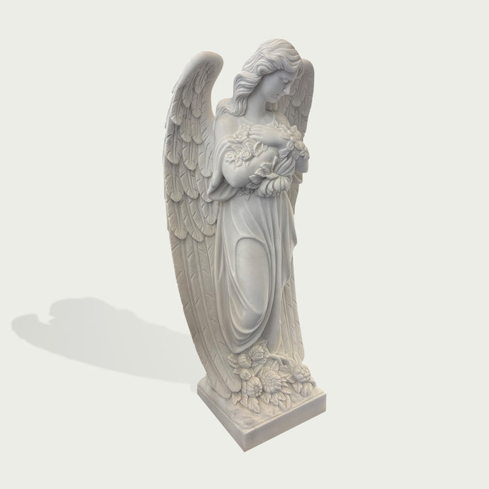 Natural white marble angel sculpture holding flowers, with detailed wings, flowing drapery, and soft carved facial features on a clean background.
