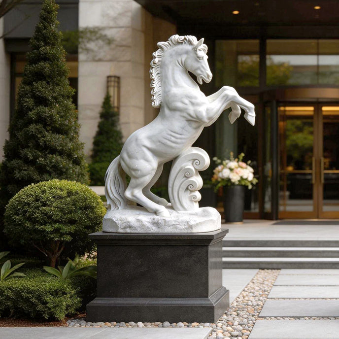 White marble rearing horse statue displayed at a luxury outdoor entrance with shrubs, stone steps, and modern building background.