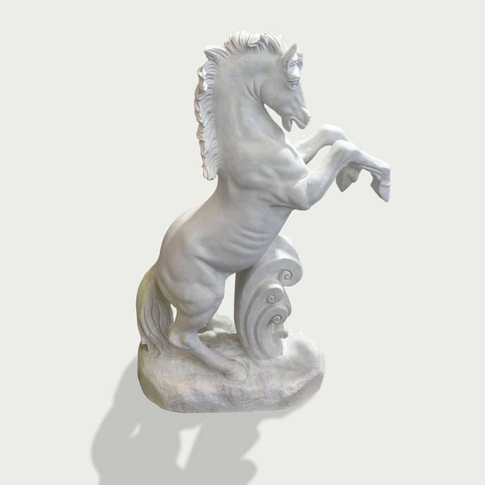 Side view of white marble rearing horse statue with flowing mane, strong body lines, and carved wave accent for outdoor display.