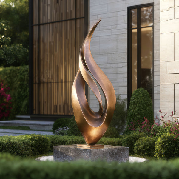 Abstract large dancing flame bronze sculpture in a garden setting with a building in the background