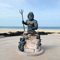 Sovereign Poseidon Bronze Sculpture on a beach with ocean and sky in the background
