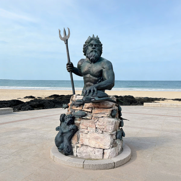 Sovereign Poseidon Bronze Sculpture on a beach with ocean and sky in the background