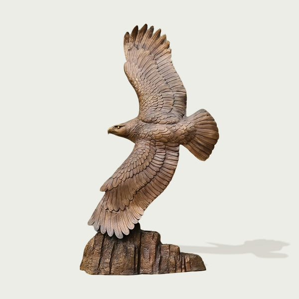 Wings of freedom eagle bronze sculpture in flight on a light gray background