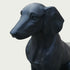 Black bronze dog statue on a light gray background