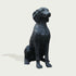 Black bronze dog statue on a light gray background