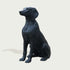 Black bronze dog statue on a light gray background