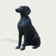 Black bronze dog statue on a light gray background