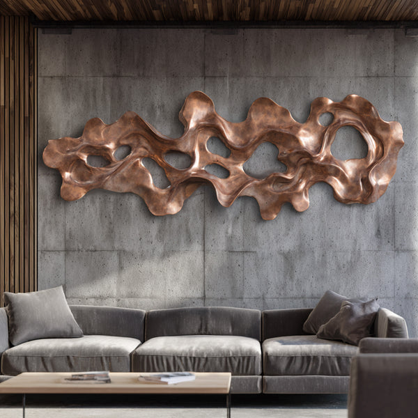 Abstract Riverflow Bronze Wall Sculpture in a mdern living room with a gray sofa