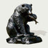 Bronze statue of a bear holding a fish on a white background