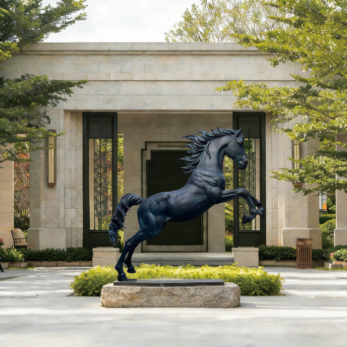 Large Rearing Bronze Horse Sculpture in front of a building with greenery