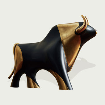 Striking Black And Gold Bronze Bull Statue with black and gold colors on a light gray background