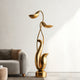  Modern Abstract Gold Floral Sculpture in a living room setting with a sofa and neutral decor.