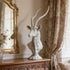  Textured Classic Antelope Bust Statue Bronze Sculpture on a wooden console table with floral curtains and a mirror in the background