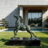 Rearing Wild Horse Sculpture in front of a modern building with a pool