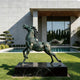 Rearing Wild Horse Sculpture in front of a modern building with a pool