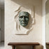 Dramatic Male Wall Art Bronze Sculpture on a textured wall with a wooden console table below.