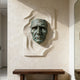 Dramatic Male Wall Art Bronze Sculpture on a textured wall with a wooden console table below.