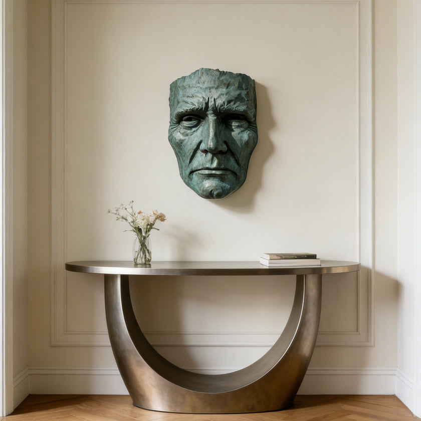 Dramatic Male Wall Art Bronze Sculpture on a wall above a modern console table with a vase and books.