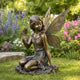 Enchanted Winged Fairy Woman Sculpture Bronze Garden Statues in a garden setting with flowers and greenery.