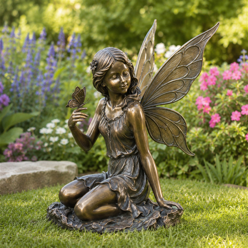 Enchanted Winged Fairy Woman Sculpture Bronze Garden Statues in a garden setting with flowers and greenery.