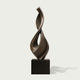 Fluid Twisting Infinity Teardrop Bronze Landscape Sculptures with a twisted, flame-like form mounted on a dark rectangular pedestal, photographed against a light gray background.