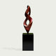 Twisting Red Bronze Flame Floor Sculpture Abstract Art Sculptures with a glossy dark reddish-brown twisted form mounted on a glossy black rectangular pedestal, shown against a light gray background.