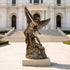 Holy Defender Classical Archangel St. Michael Bronze Sculpture defeating a serpent, displayed on a stone pedestal in front of a grand neoclassical building with wide stone steps.