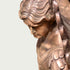 Close-up of a Holy Defender Classical Archangel St. Michael Bronze Sculpture showing the side profile of the face, flowing hair, and wing details against a plain light background.