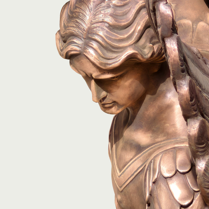 Close-up of a Holy Defender Classical Archangel St. Michael Bronze Sculpture showing the side profile of the face, flowing hair, and wing details against a plain light background.