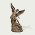 Holy Defender Classical Archangel St. Michael Bronze Sculpture standing on a rocky base and defeating a serpent, photographed against a plain light gray background with a soft shadow cast to the right.