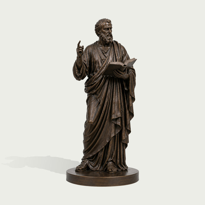 St. Mark The Evangelist Bronze Sculpture Classical Sculpture in draped robes, holding an open book and raising one hand, displayed on a round pedestal against a light gray background.