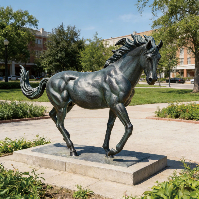 Classical bronze horse statue in a landscaped garden setting, showing detailed horse anatomy, elegant posture, sculpted mane and weather-resistant bronze finish.