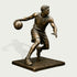 Detailed bronze basketball player statue capturing an athlete mid-dribble with one hand controlling the ball, a defensive arm extended, and legs in motion, finished with realistic uniform folds, shoes, and defined musculature.