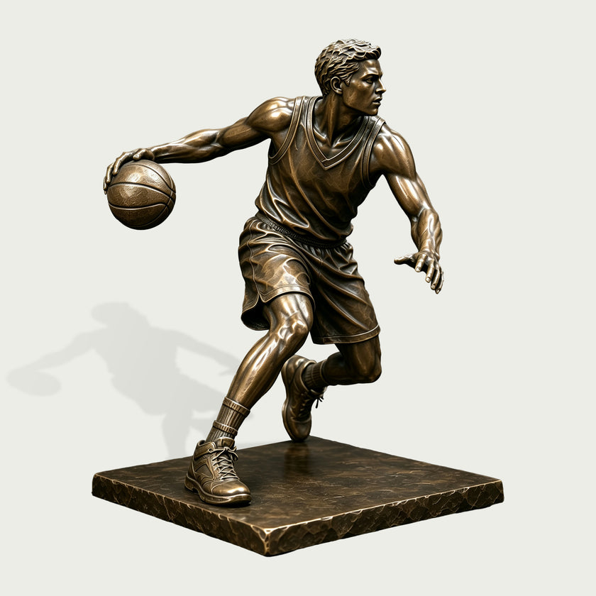 Detailed bronze basketball player statue capturing an athlete mid-dribble with one hand controlling the ball, a defensive arm extended, and legs in motion, finished with realistic uniform folds, shoes, and defined musculature.