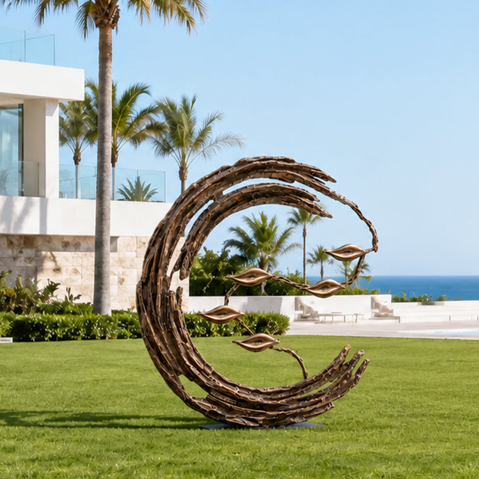 Abstract bronze crescent garden sculpture installed on a green lawn at a coastal villa, with textured sweeping branches and delicate floating leaves framed by palm trees, modern architecture, and an ocean view.