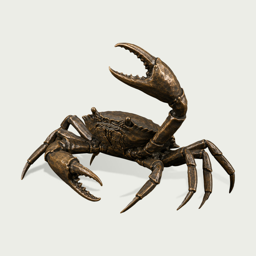 Antique bronze crab sculpture shown in a three-quarter view, featuring dramatic open pincers, multiple articulated legs, raised eyes, a richly textured shell, and hand-finished golden highlights across the dark bronze surface.