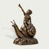 Detailed bronze garden sculpture of a barefoot boy sitting on a large snail and reaching upward toward a butterfly, mounted on a textured rock-style base.