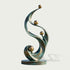 Front product view of an abstract bronze sculpture featuring elegant S-shaped verdigris ribbons, multiple polished golden spheres, and a round bronze base.