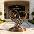 Large bronze dove sculpture displayed at a luxury residence entrance, featuring two birds, an olive branch, and flowing heart-shaped curves on a round bronze base.