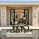 A bronze sculpture of a giant octopus displayed in a modern reflective pool. This lifelike marine metal art features a smooth rounded head and spreading tentacles with suction cup details, creating a luxurious aquatic centerpiece for a contemporary courtyard.