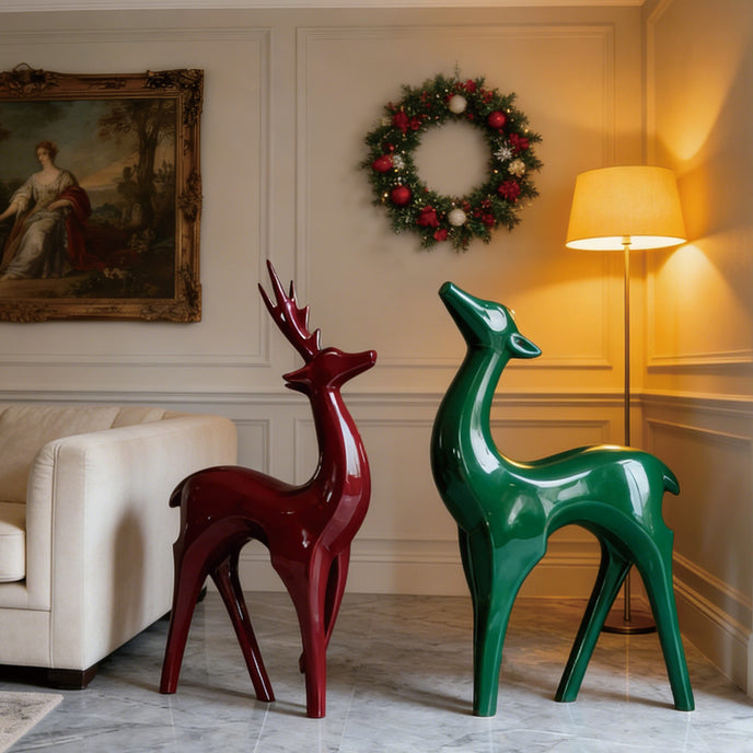 Vibrant Fiberglass Sculpture Christmas Reindeer Pair For Modern Decor. Two decorative deer statues, one red and one green, in a living room setting with a wreath on the wall.
