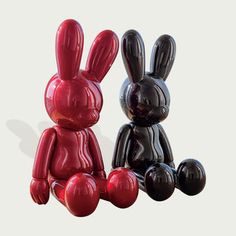 Two Avant-Garde Giant Seated Rabbit Fiberglass Sculpture in red and black color on a light gray background