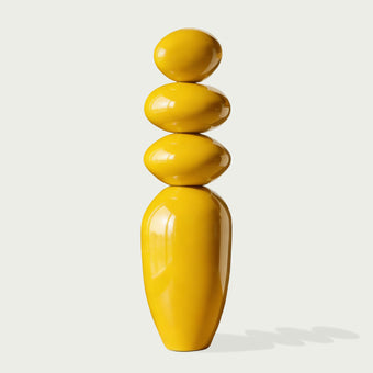 A Modern Glossy Yellow Stacked Pebble Fiberglass Sculpture on a white background
