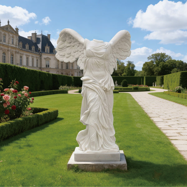 Classic Greek Winged Victory Of Samothrace Marble Statue Replica in a garden with a castle in the background