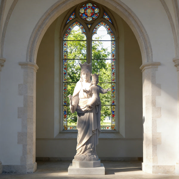 Blessed Virgin Mary And Christ Child Marble Statue in front of a stained glass window in a church.