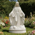 Mother Mary Our Lady Of Grace Marble Statue For Church Gardens in a garden with flowers and greenery