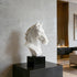 Modern Geometric Natural White Marble Horse Head Sculpture on a black pedestal against a gray wall.
