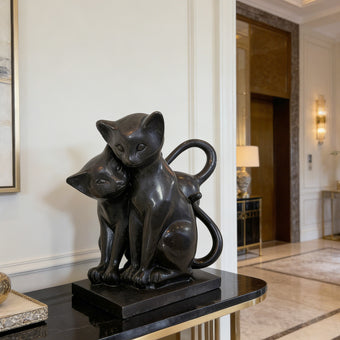 Modern Black Natural Marble Cats Statue  on a black marble base in an elegant interior setting.