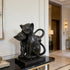 Modern Black Natural Marble Cats Statue  on a black marble base in an elegant interior setting.
