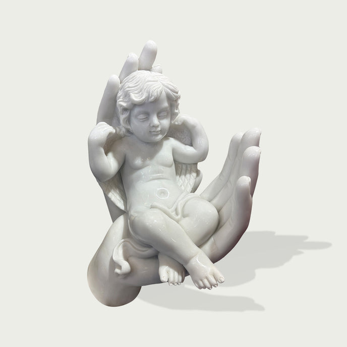 Sleeping Angel In Hands Natural Marble Statue on a hand against a light gray background
